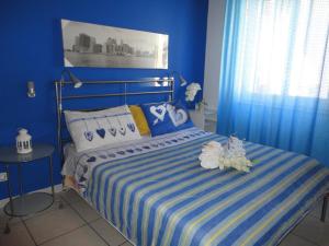 a blue bedroom with a bed with two stuffed animals on it at Travel and Living in Trani