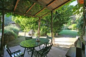 patio con tavolo e sedie sotto un pergolato di Agriturismo "Borgo Madonna degli Angeli" - charming cottages in the gardens ! a Tocco da Casauria