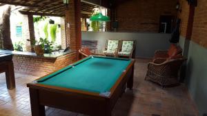 uma mesa de bilhar no meio de uma sala de estar em Pousada Barcelos em São Roque de Minas