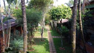 a path through a garden with palm trees at Pousada Barcelos in São Roque de Minas
