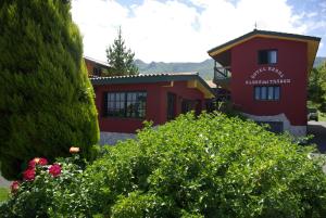 a red building with a bunch of flowers in front of it at Aldea del Trasgu in Cuerres