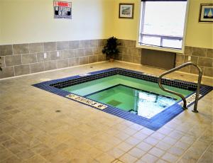 a swimming pool in a room with a tile floor at Sigma Inn & Suites Hudson's Hope in Hudson Hope