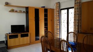 a living room with a table and a tv and a dining room at The roof garden in Marsaskala