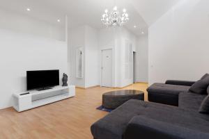 sala de estar con sofá y TV de pantalla plana en BIG Central City Apartment West Kurfurstendamm en Berlín