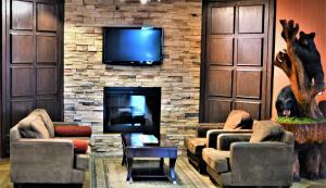 
a living room filled with furniture and a fire place at Sigma Inn & Suites Hudson's Hope in Hudson Hope
