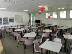 ein leeres Klassenzimmer mit Tischen und Stühlen in der Unterkunft Ostello Domus Augusta Aquileia in Aquiléia