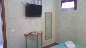 a bathroom with a television and a table with a mirror at La Casa Dei Delfini in Lampedusa
