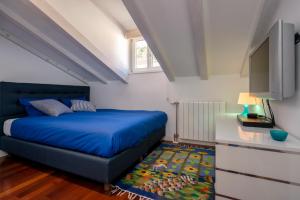 Schlafzimmer mit einem blauen Bett und einem Flachbild-TV in der Unterkunft Luxury Apartment Bifora in Hvar