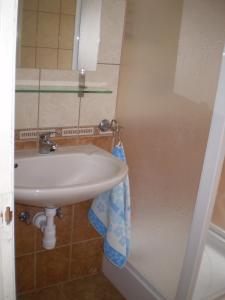 baño con lavabo y toalla azul en Belvárosi Apartman Kőszeg, en Kőszeg