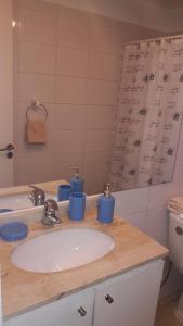 Un baño con lavabo con tazas azules. en DV Apartments, en Santiago