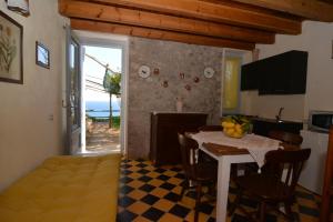 a kitchen and dining room with a table and a room with a window at Bella Baia Relais in Maiori