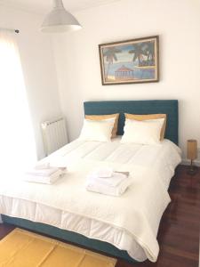 1 dormitorio con 1 cama con 2 toallas en Beach House en Madalena