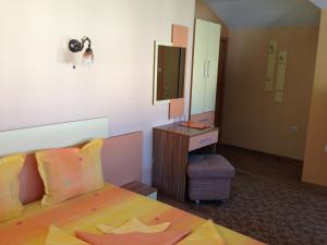 1 dormitorio con cama, tocador y espejo en Guest House Lori, en Teteven