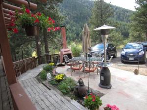 eine Terrasse mit einem Tisch, Stühlen und einem Sonnenschirm in der Unterkunft Kokopelli Inn in Estes Park