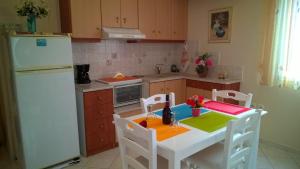 a kitchen with a white table and a white refrigerator at Stolidi in Adamas