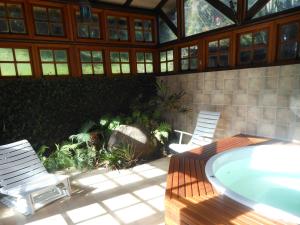 un patio con 2 sedie e una vasca idromassaggio di Pousada Refúgio do Lago a São Francisco de Paula