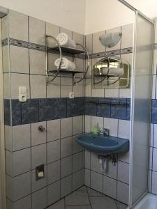 een badkamer met een blauwe wastafel en een spiegel bij Lavender Apartment in Siófok