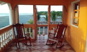 two chairs sitting on a balcony looking out at the ocean at Sunset Waves House in San Diego