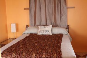 Una cama con una almohada que dice casa de playa en Sunset Waves House en San Diego