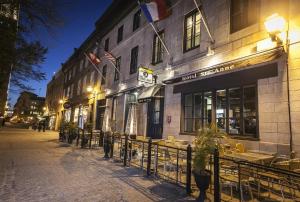 a street with tables and chairs in front of a building at Hôtel Sainte-Anne in Quebec City