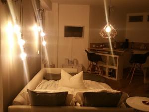 a living room with a bed with pillows and lights at Apartment am Zoo in Krefeld