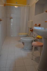 ein Badezimmer mit 2 WCs, einem Waschbecken und einem Waschbecken in der Unterkunft Appartamenti Villa Annunziata in Ischia