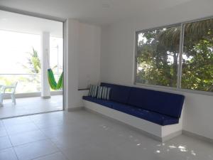 a blue couch in a room with a large window at Condominio Milagros Coveñas in Coveñas