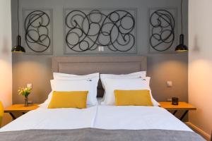 ein Schlafzimmer mit einem weißen Bett mit zwei gelben Kissen in der Unterkunft The Well Luxury Rooms in Zadar