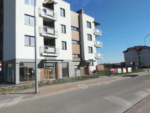 a tall white building on the side of a street at Apartamenty Pisz in Pisz