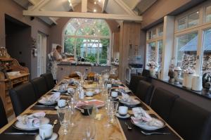 a dining room with a long table with plates and glasses at B&B 't Heirweggoed in Assenede +35 photos