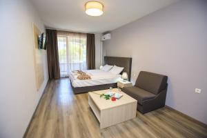 サンダンスキにあるApartments K&M Sandanskiのベッドルーム1室(ベッド1台、ソファ、椅子付)