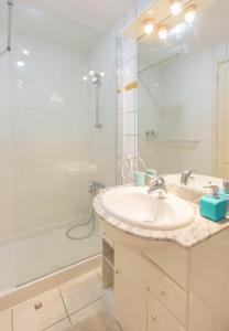 y baño blanco con lavabo y ducha. en Marine Breeze Apartment, en Corralejo