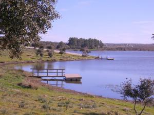 un lago con panchine e un molo in acqua di Casa Nazare a Vilar Torpim