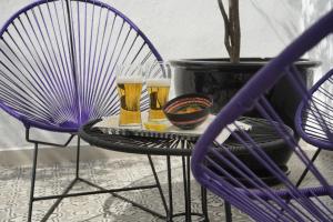 two glasses of beer on a table with two chairs at Casa Goliana La Roma in Mexico City +22 photos