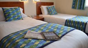 Habitación de hotel con 2 camas y un libro en la cama en Heights Hotel, en Portland