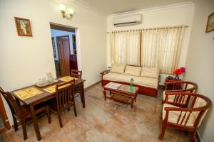 Manasarovar Homes - Rajalakshmi Serviced Apartments في تيروفانمالي: غرفة معيشة مع طاولة وأريكة
