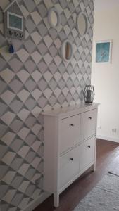 een kamer met een witte dressoir en een geometrische muur bij Apartament Papaj in Giżycko