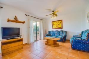 アルクーディアにあるVilla Marcos Lago Esperanzaのリビングルーム(青い椅子2脚、薄型テレビ付)