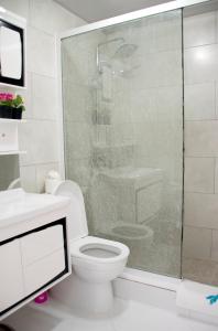 een badkamer met een toilet en een glazen douche bij El Cabarete Spa Resort all-Inclusive in Cabarete