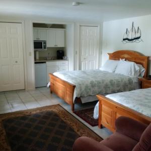 a bedroom with two beds and a kitchen at Caprice in Gibsons