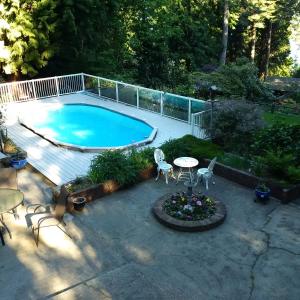 an overhead view of a swimming pool with a table and chairs at Caprice in Gibsons
