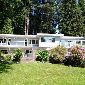 a large white house with a yard at Caprice in Gibsons