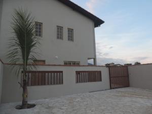 una casa blanca con una valla y una palmera en Pousada Solar do Jabaquara, en Paraty