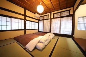 1 dormitorio con 1 cama en una habitación con ventanas en Utatei, en Takayama