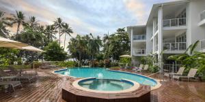 a swimming pool in front of a building at Beaches Holiday Apartments - Official Onsite Reception & Check In in Port Douglas
