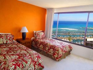 1 Schlafzimmer mit 2 Betten und einem großen Fenster in der Unterkunft Waikiki Vacation 10 in Honolulu