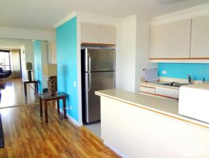 Il comprend une cuisine équipée d'un réfrigérateur et d'une table. dans l'établissement Waikiki Vacation 10, à Honolulu