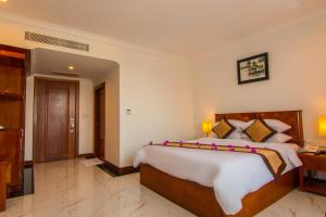 a bedroom with a bed and a dresser at Glorious Hotel & Spa in Kompong Thom