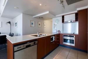 een keuken met een wastafel en een fornuis top oven bij Apartment with Ocean Views in Gold Coast