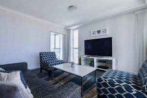 een woonkamer met een bank en een tv bij Apartment with Ocean Views in Gold Coast